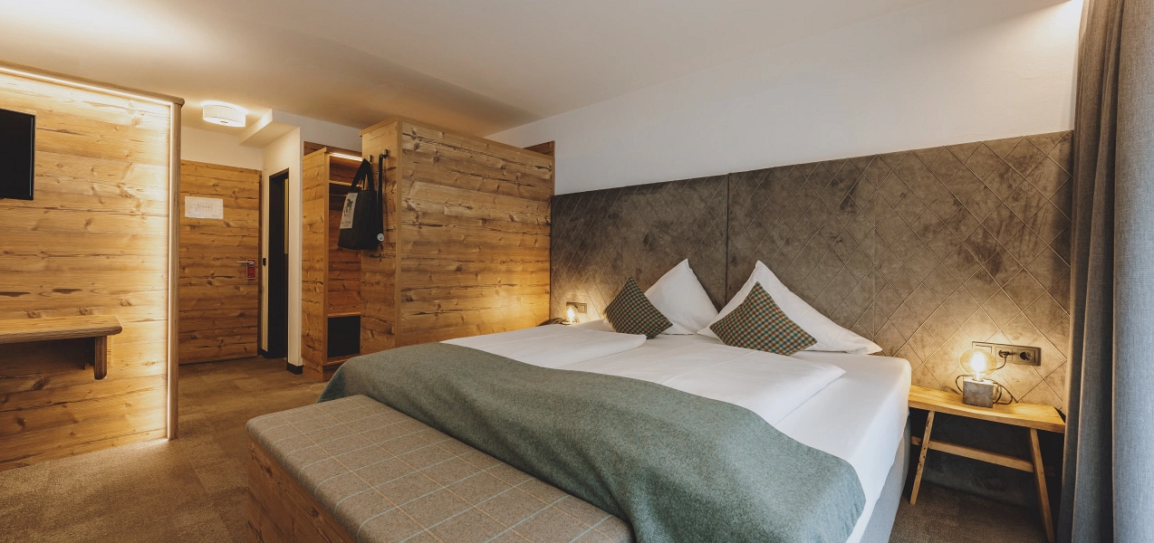 Heller Hotelzimmer mit Holzelementen und komfortablem Bett