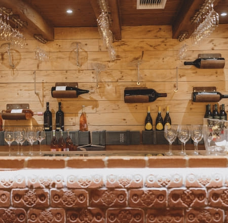 Weinlounge mit Weinen und Gläsern an der Wand