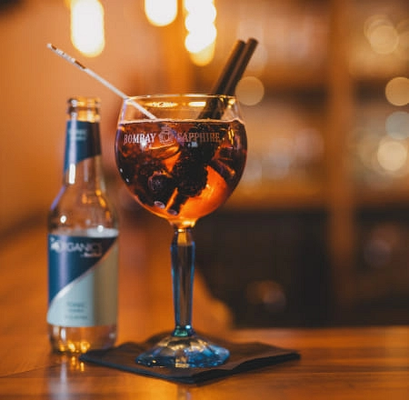 Cocktail im Glas mit Flasche daneben