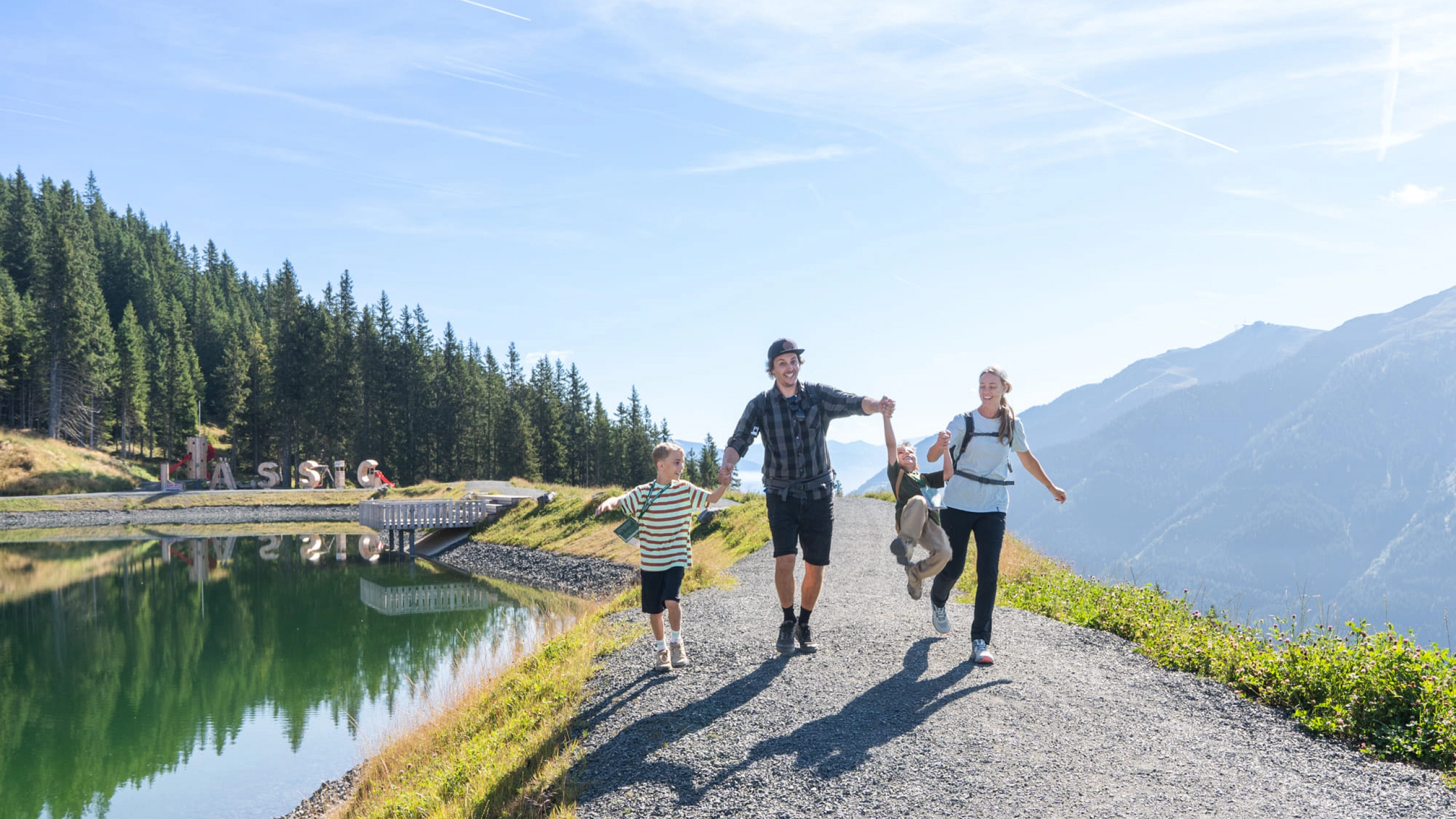 Familie wandert am Reiterkogel entlang eines Sees.